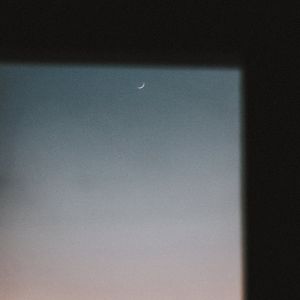 Blue sky visible through a window frame during daytime.