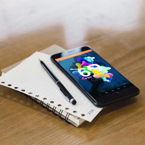 Close up of a wooden desk with a notebook.
