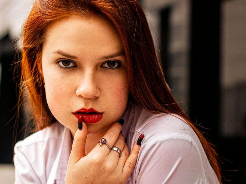 Person focusing on a distant point through a window in a bright room.